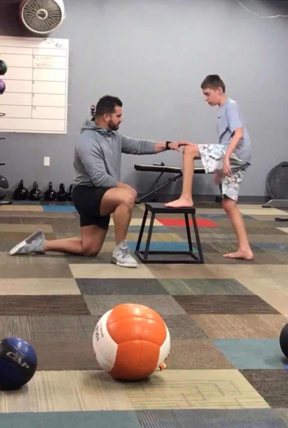 Clayton Rice assists a child with Cerebral Palsy with their physical therapy